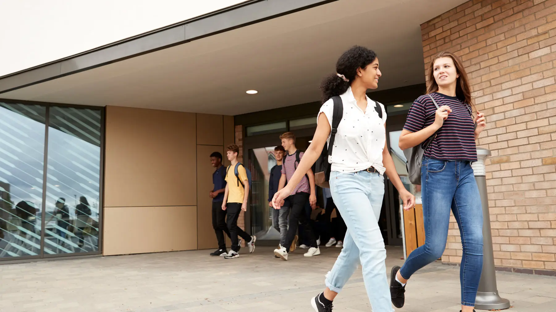 High school students walking out of school together
