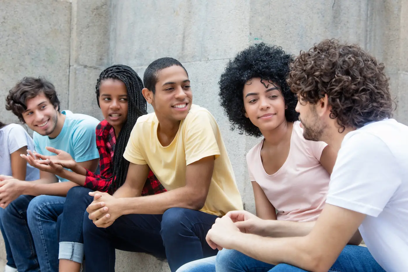 A group of teenagers talking and laughing together outside